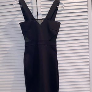Black dress with mesh cut outs on top and sides. Zips in back.
